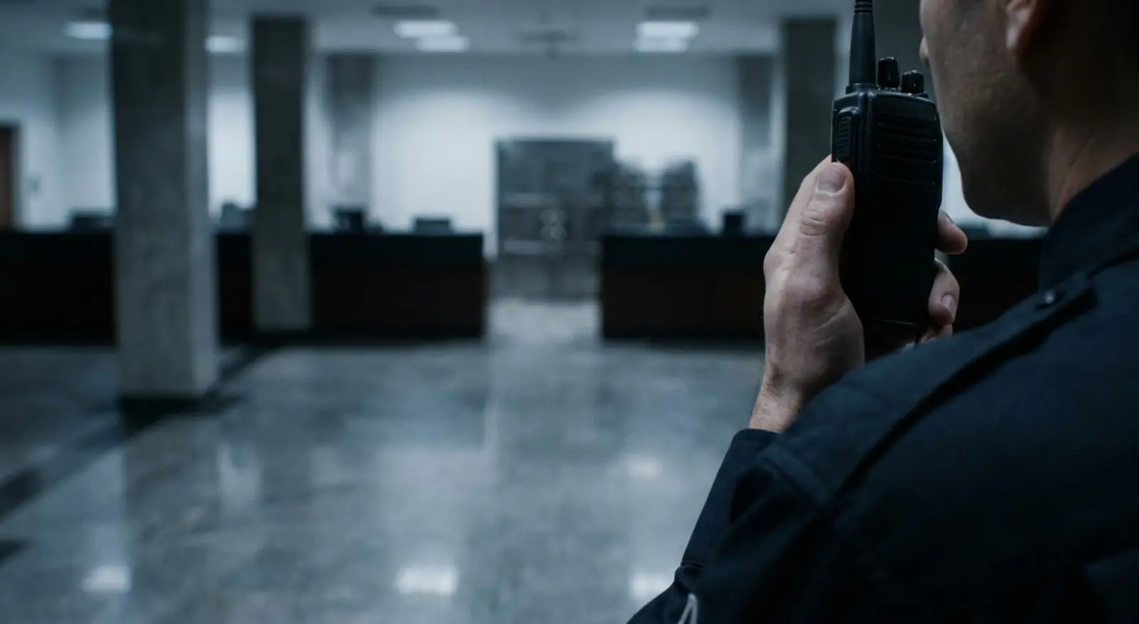 A guard talks on the radio in a bank lobby