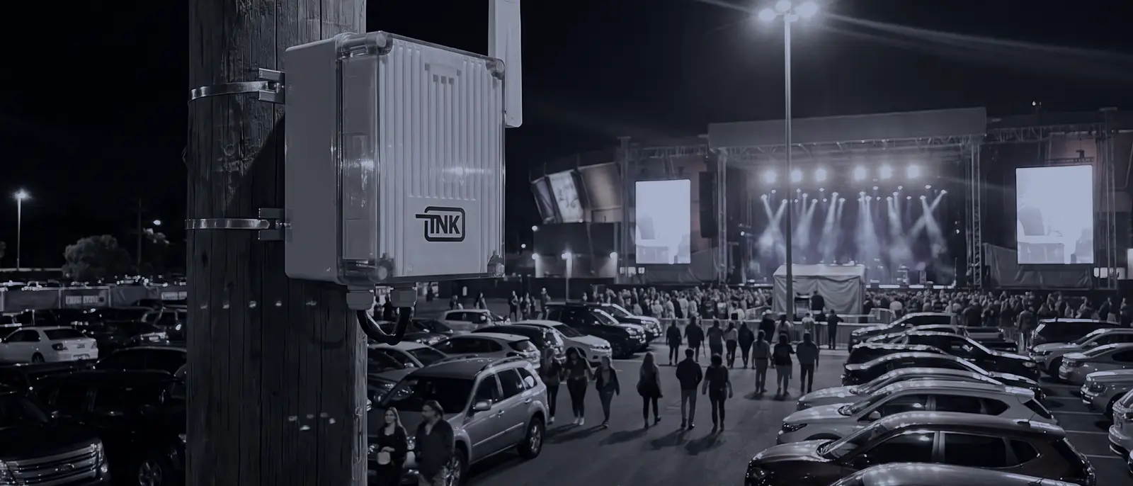 CarDefense fixed sensor mounted on a pole above the parking lot of an event venue at night