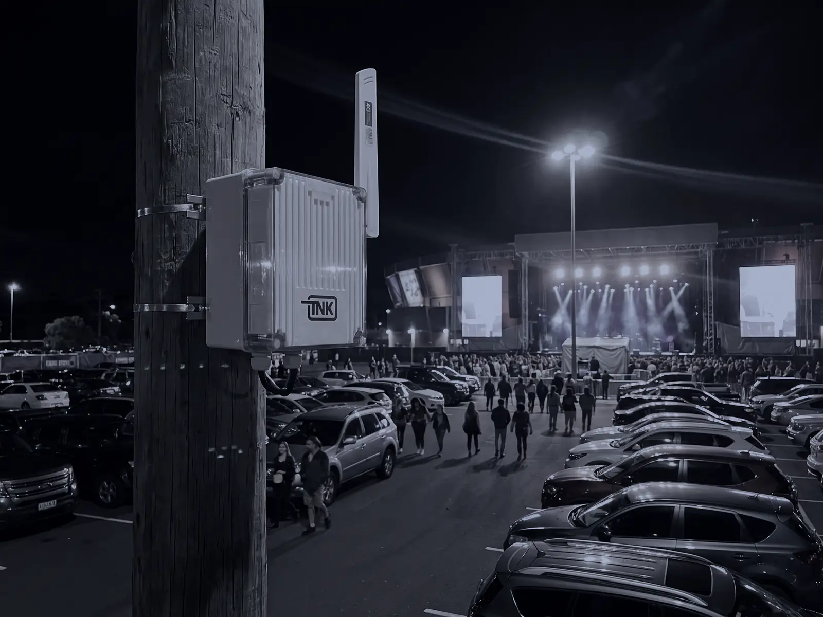 CarDefense fixed sensor on a pole above the parking lot of a concert at night