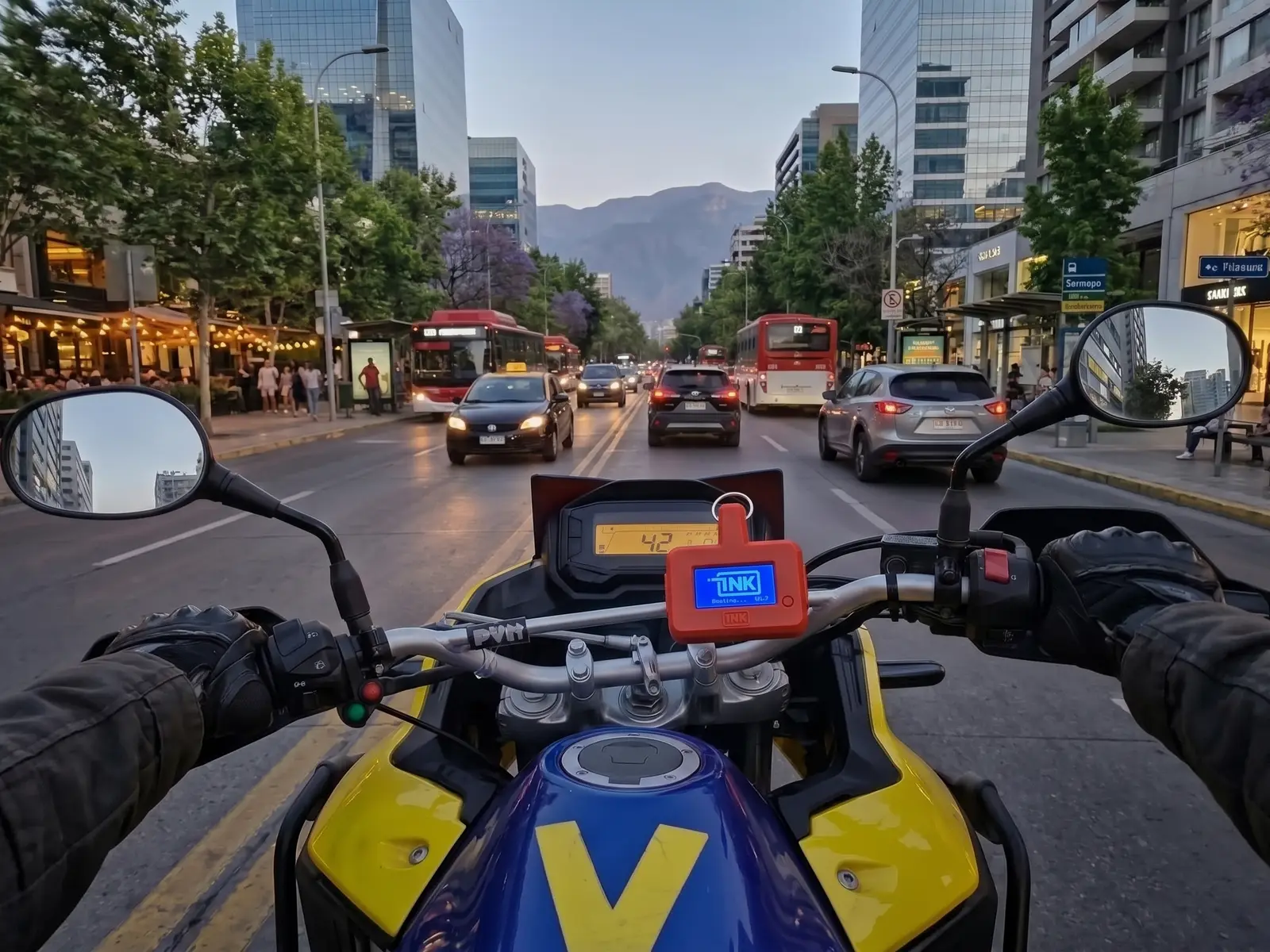 CarDefense Mobile on the handlebar of a motorcycle riding down an avenue