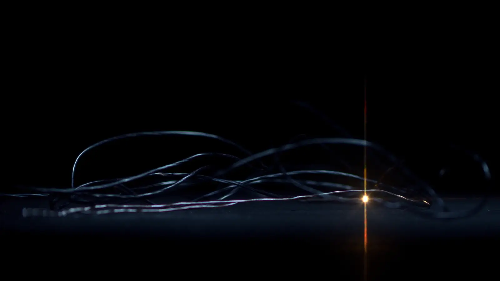 Cables on a dark surface with a single point of warm light